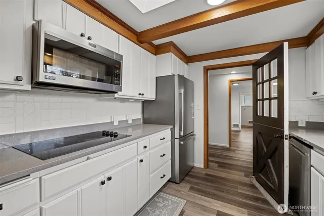 a kitchen with stainless steel appliances a stove a microwave and a refrigerator