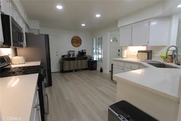 a kitchen with a refrigerator and a stove top oven