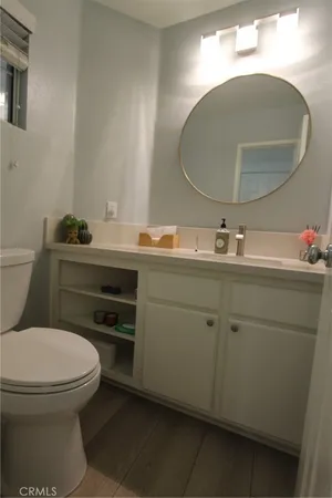 a bathroom with a toilet a sink and mirror