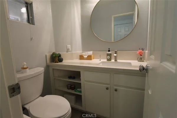 a bathroom with a toilet sink and mirror