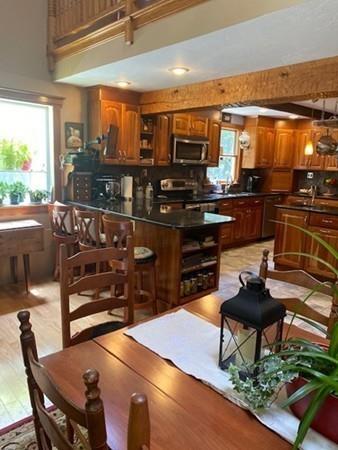 70 Cutler Road Holden, MA 01522 - Photo 9 of 28 a kitchen with stainless steel appliances wooden floor dining table and chairs