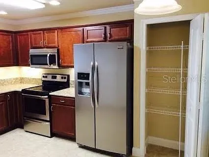 a kitchen with stainless steel appliances granite countertop a refrigerator and a stove