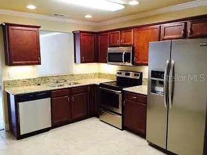 a kitchen with granite countertop stainless steel appliances and wooden cabinets
