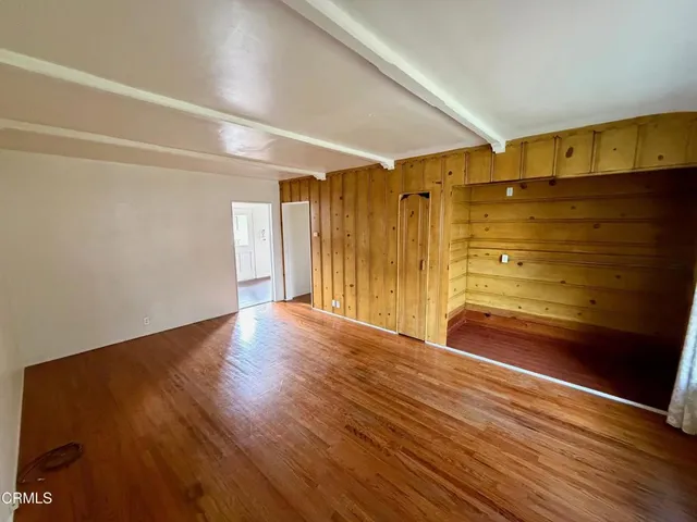 a view of empty room with wooden floor