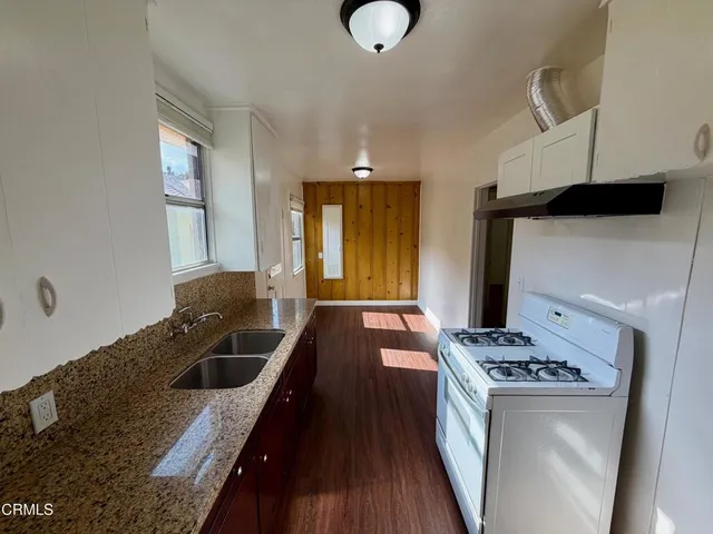 a kitchen with granite countertop a stove and cabinets
