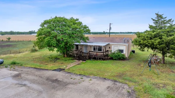 a kitchen with stainless steel appliances a refrigerator a sink a stove and white cabinets with wooden floor
