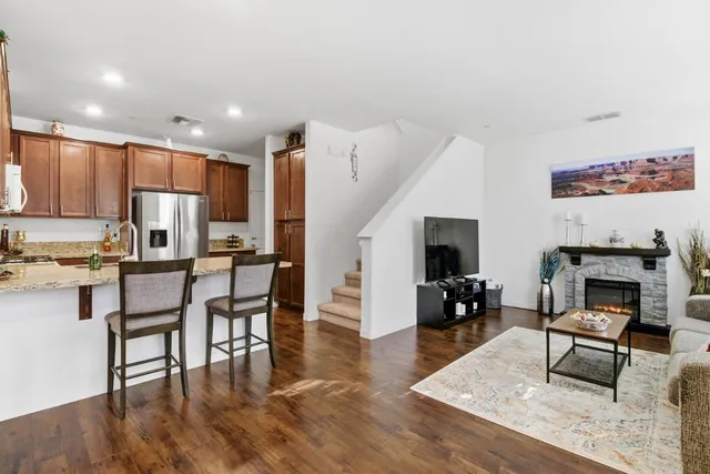 a living room with furniture a fireplace and kitchen view