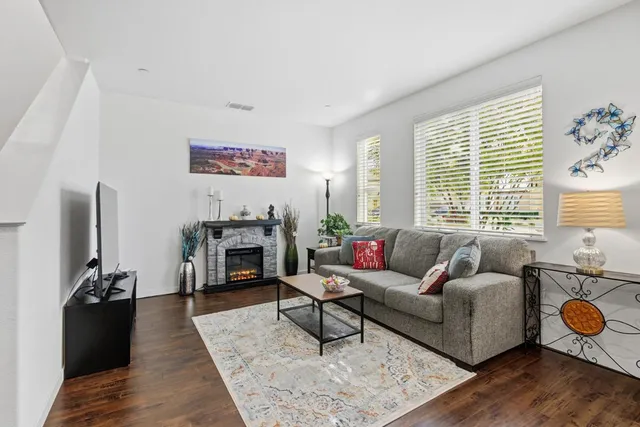 a living room with furniture a fireplace and a large window