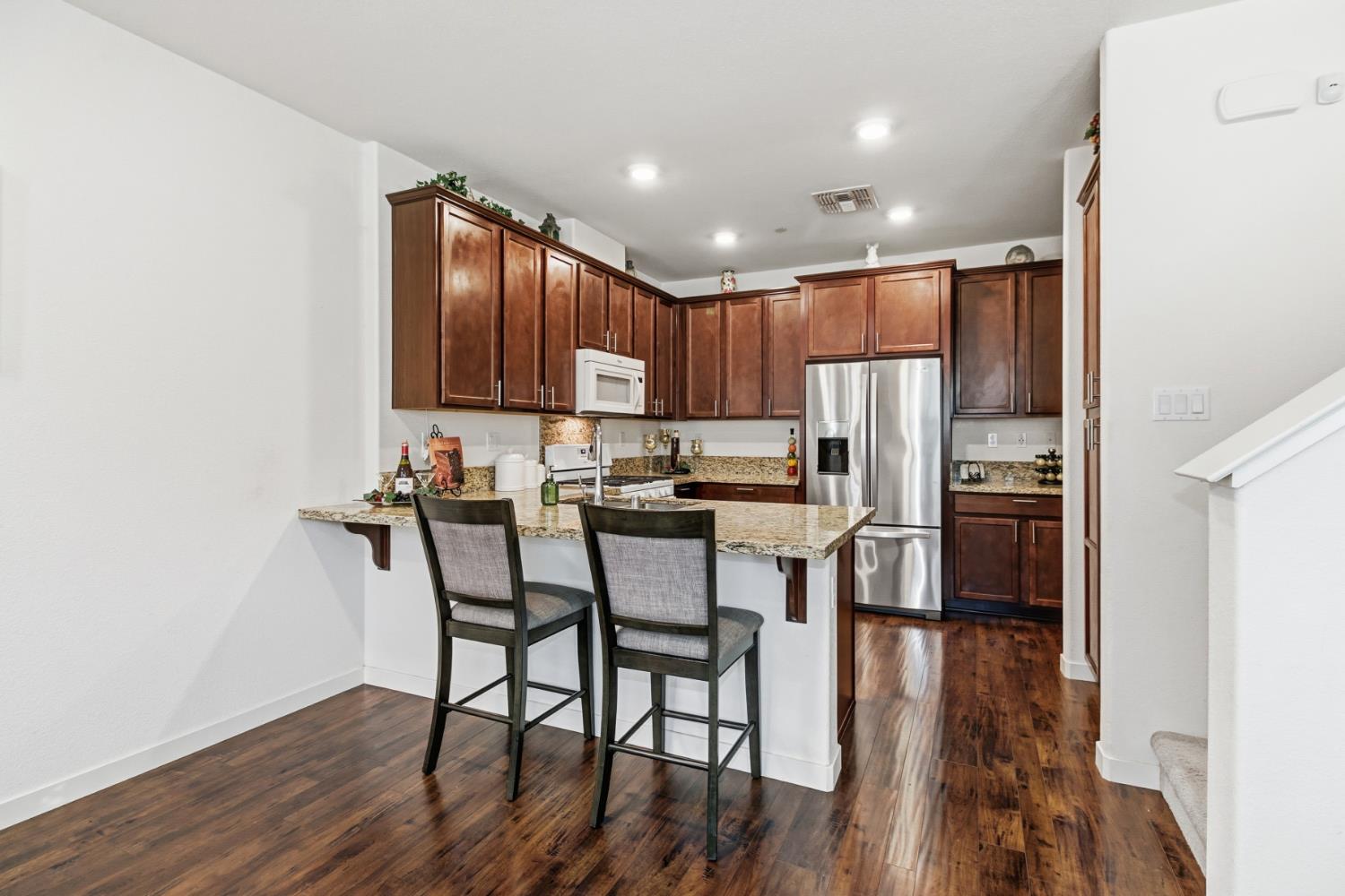 3215 Bridgeway Drive Rancho Cordova, CA 95670 - Photo 7 of 32 a kitchen with kitchen island granite countertop wooden floors cabinets and stainless steel appliances