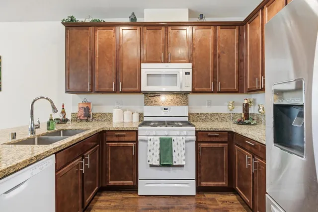 a kitchen with stainless steel appliances granite countertop a stove sink and cabinets