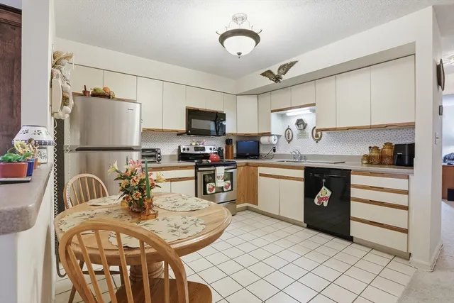 a kitchen with stainless steel appliances kitchen island granite countertop a sink cabinets and refrigerator