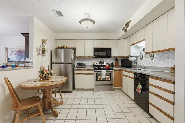 a dining room with furniture and kitchen view
