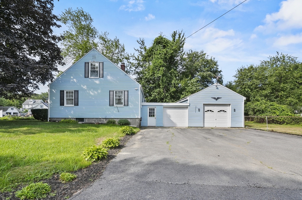 305 Whalom Road Lunenburg, MA 01462 - Photo 4 of 29 a front view of a house with a yard and garage