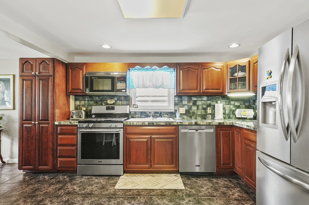 305 Whalom Road Lunenburg, MA 01462 - Photo 9 of 29 a kitchen with stainless steel appliances granite countertop a refrigerator and a stove top oven