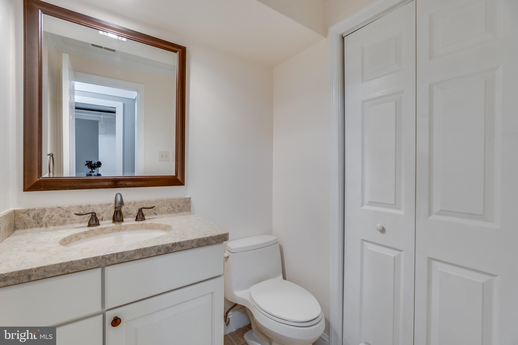 2069 Cobblestone Lane Reston, VA 20191 - Photo 28 of 35 a bathroom with a toilet a sink a vanity and mirror