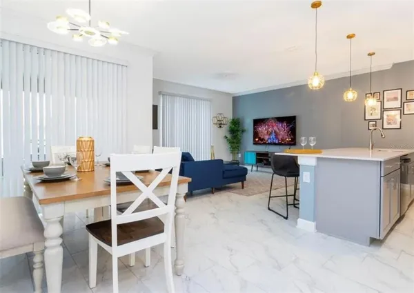 a living room with furniture a flat screen tv and kitchen view