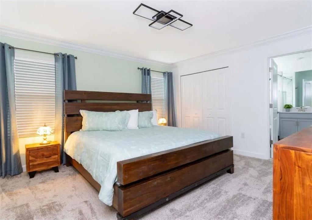 984 Leader Street Davenport, FL 33896 - Photo 4 of 6 a bed sitting in a bedroom next to a window and a chandelier