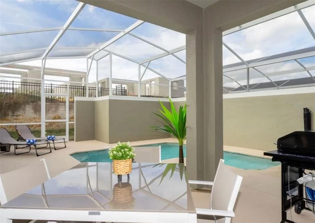 984 Leader Street Davenport, FL 33896 - Photo 6 of 6 a view of a porch with chairs and potted plants