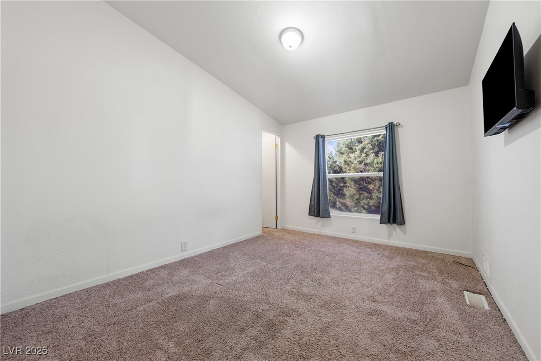 633 East Simkins Road Pahrump, NV 89060 - Photo 16 of 25 Carpeted 2nd bedroom featuring visible vents and baseboards