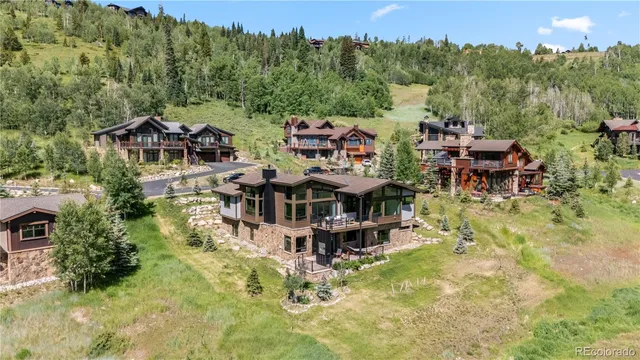an aerial view of a house with swimming pool and a yard