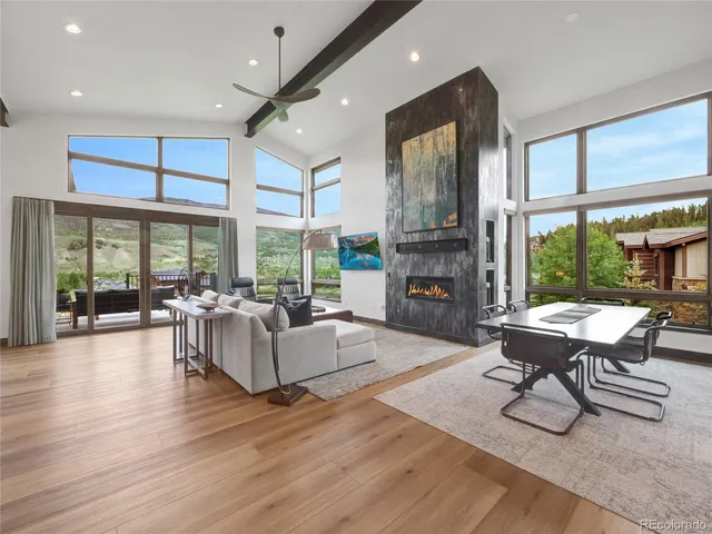 a living room with fireplace furniture and a large window