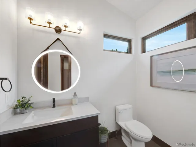 a bathroom with a toilet a sink and mirror