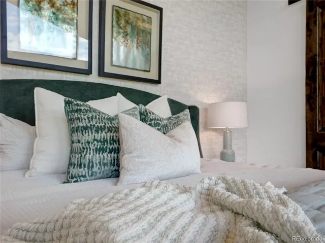 a bedroom with a bed and a painting on the wall