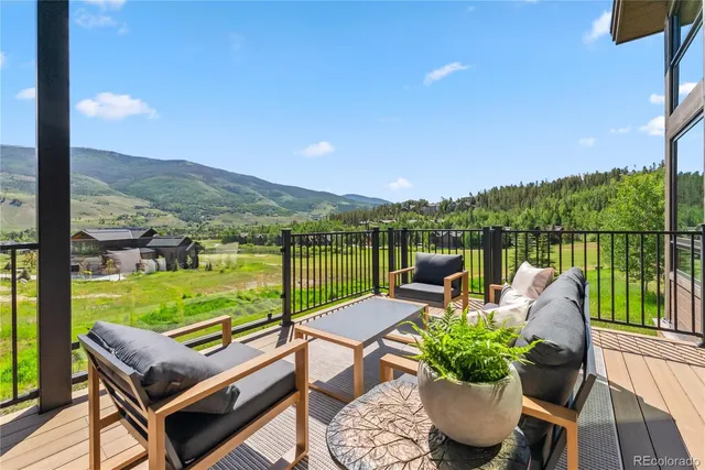 a view of a patio with couches potted plants and ocean view