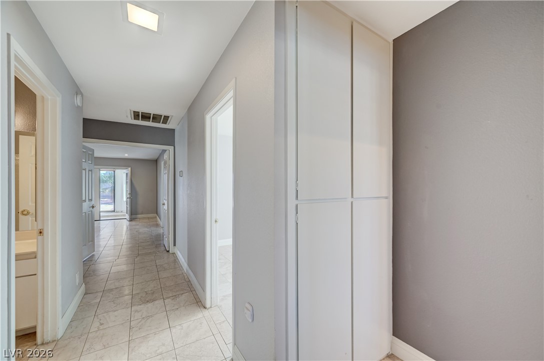 6635 Costa Brava Road Las Vegas, NV 89146 - Photo 45 of 59 A long, tiled hallway provides clear lines of sight to other rooms and a bright outdoor area.