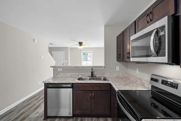 a kitchen with stainless steel appliances granite countertop a sink stove and microwave