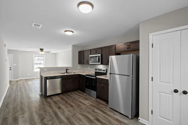 a kitchen with a refrigerator sink and wooden cabinets