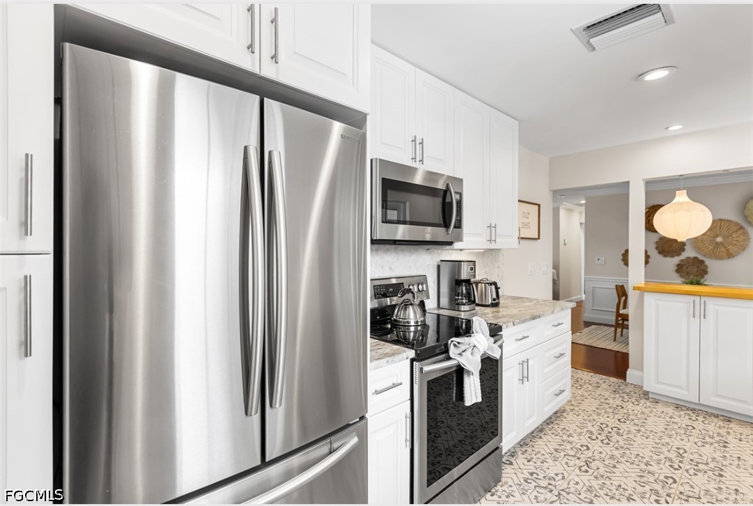 3950 Mohawk Place Naples, FL 34112 - Photo 11 of 25 a kitchen with stainless steel appliances granite countertop a refrigerator a stove a sink and a microwave