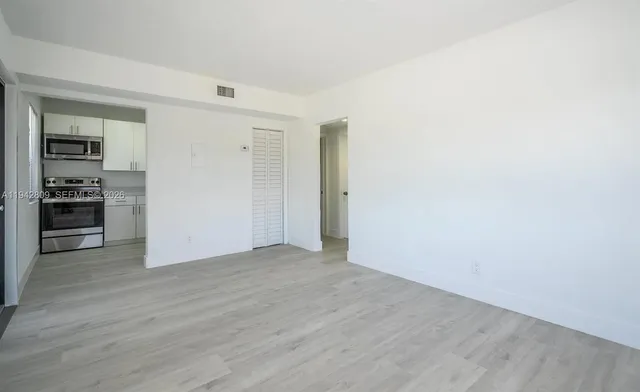 a view of empty room with wooden floor