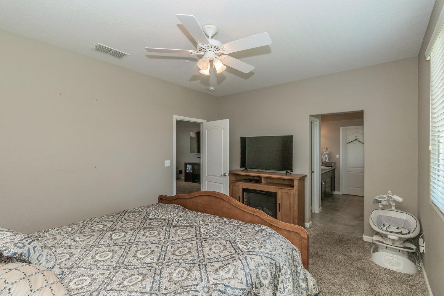 3263 Monviso Lane Clovis, CA 93619 - Photo 15 of 30 a bedroom with a large bed and a flat screen tv