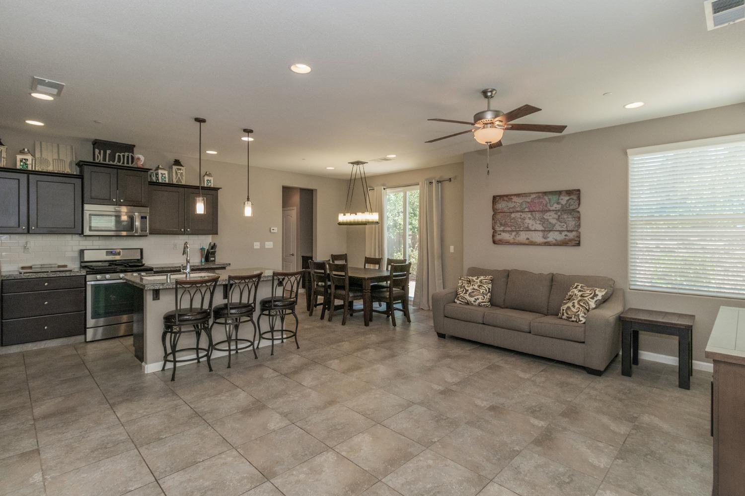 3263 Monviso Lane Clovis, CA 93619 - Photo 3 of 30 a living room with furniture a dining table and kitchen view