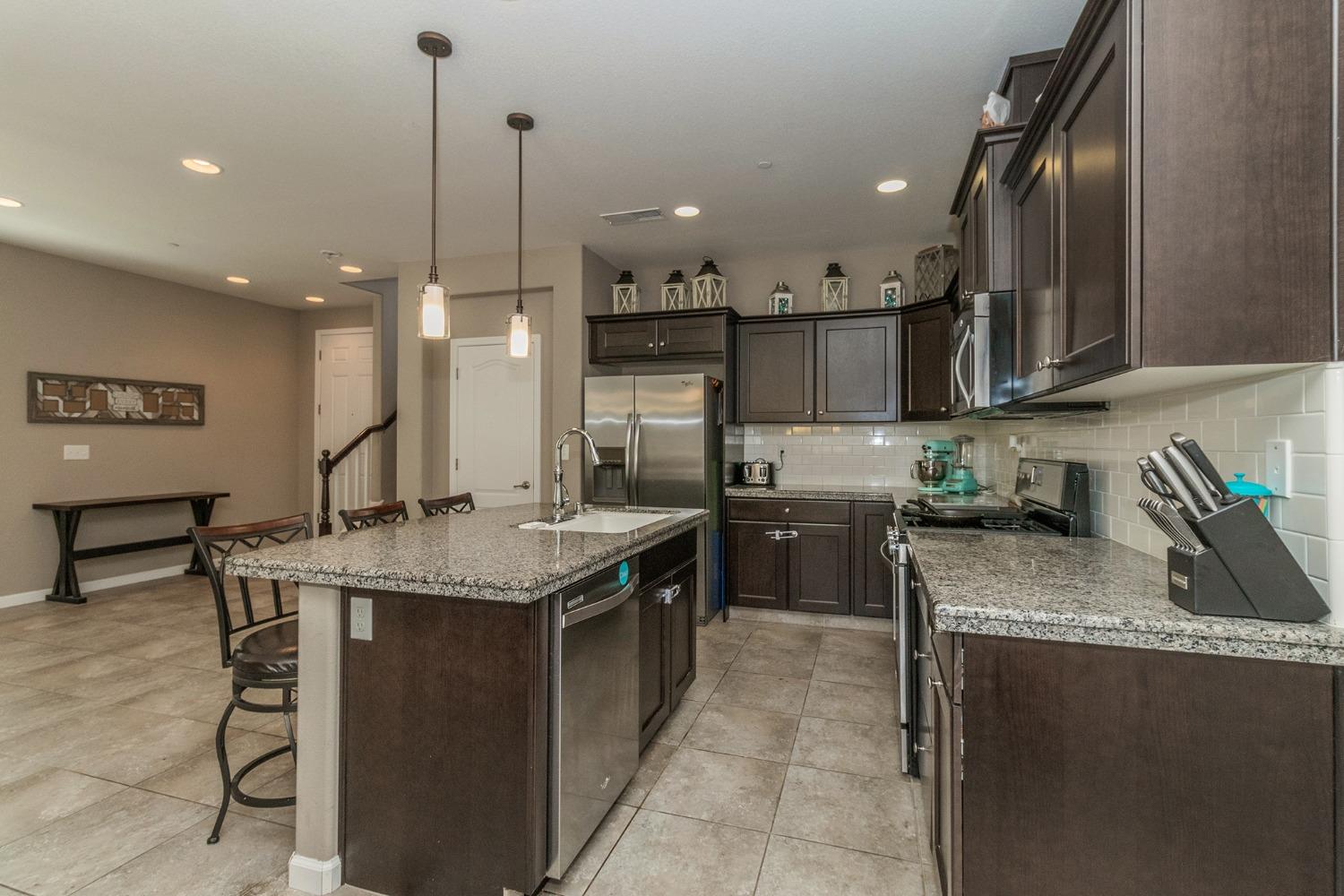 3263 Monviso Lane Clovis, CA 93619 - Photo 10 of 30 a kitchen with stainless steel appliances granite countertop a sink a stove and a wooden floors
