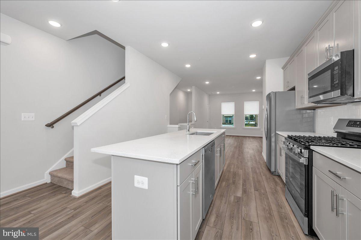 3357 Cormorant Drive Laurel, MD 20724 - Photo 12 of 41 a kitchen with stainless steel appliances kitchen island hardwood floor sink stove and cabinets