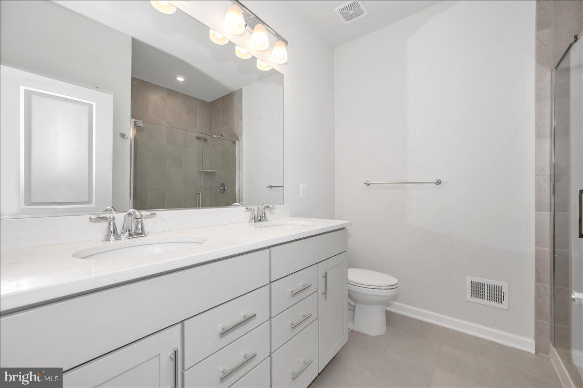 3357 Cormorant Drive Laurel, MD 20724 - Photo 28 of 41 a bathroom with a double vanity sink toilet and a mirror