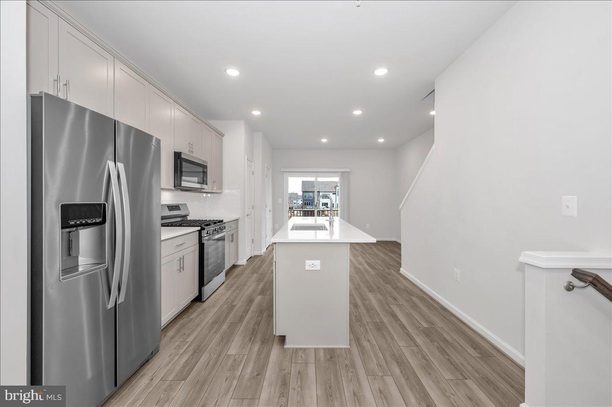 3357 Cormorant Drive Laurel, MD 20724 - Photo 9 of 41 a view of a kitchen with a refrigerator a stove top oven and wooden floor
