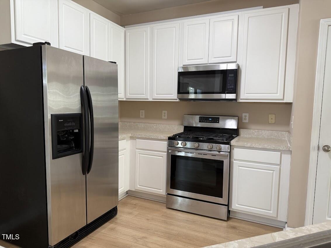 4429 Log Cabin Drive Raleigh, NC 27616 - Photo 8 of 27 a kitchen with stainless steel appliances a refrigerator stove and microwave