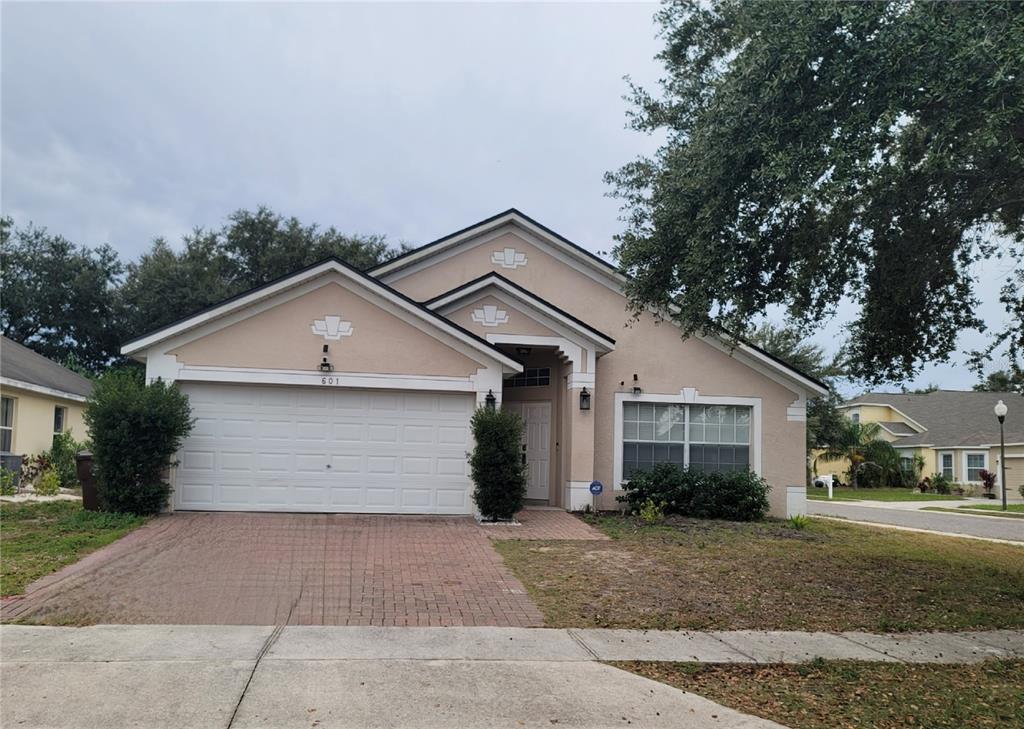 601 Astor Drive Haines City, FL 33844 - Photo 2 of 18 a front view of house with yard and trees around