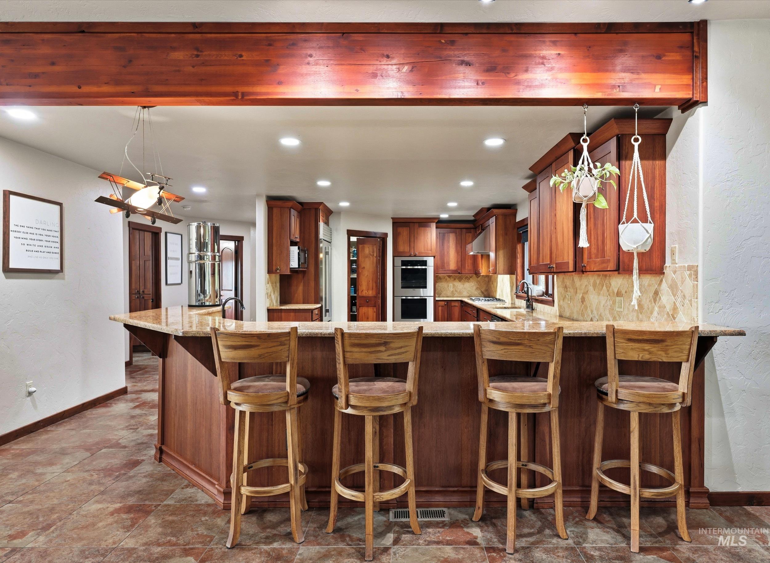 339 Airport Road Weiser, ID 83672 - Photo 12 of 49 Kitchen with a breakfast bar featuring a stone countertop and a dark wood base