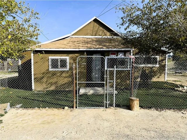 a view of wooden house with a yard covered in snow