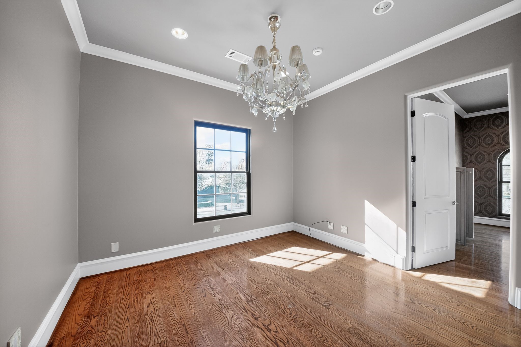 11117 Beinhorn Road Houston, TX 77024 - Photo 16 of 48 a view of an empty room with a window and wooden floor