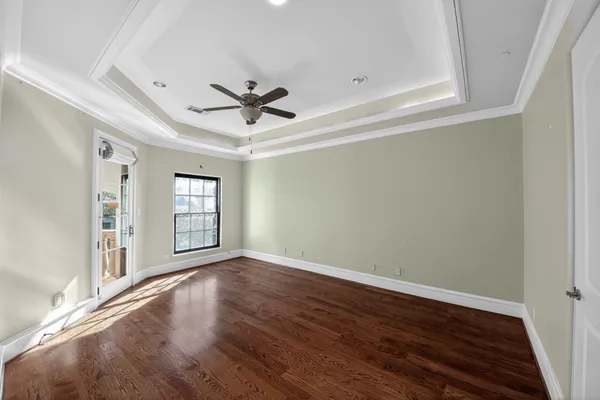 a view of a livingroom with wooden floor and a ceiling fan