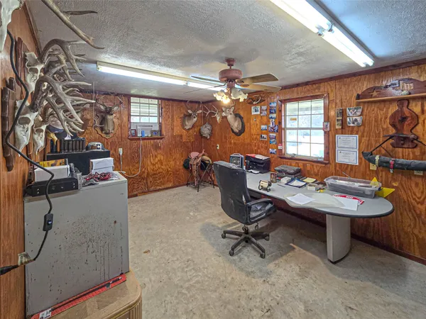 a view of a workspace with furniture and a chandelier fan