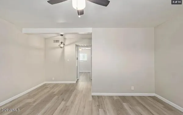 a view of a room with wooden floor and a ceiling fan