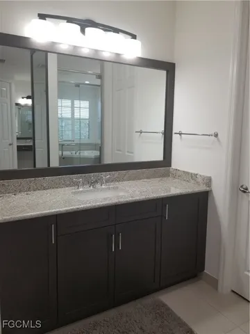 a bathroom with a granite countertop sink and a mirror