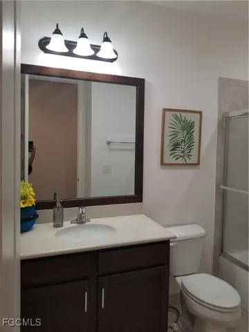 a bathroom with a toilet a sink and mirror