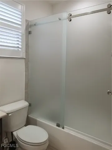 a white toilet sitting next to a bath tub